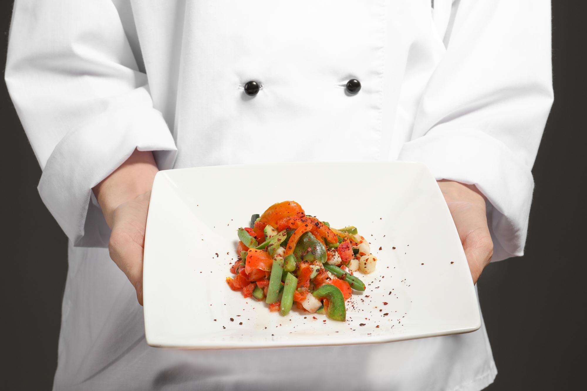 Chef che prepara una composizione su piatto elegante